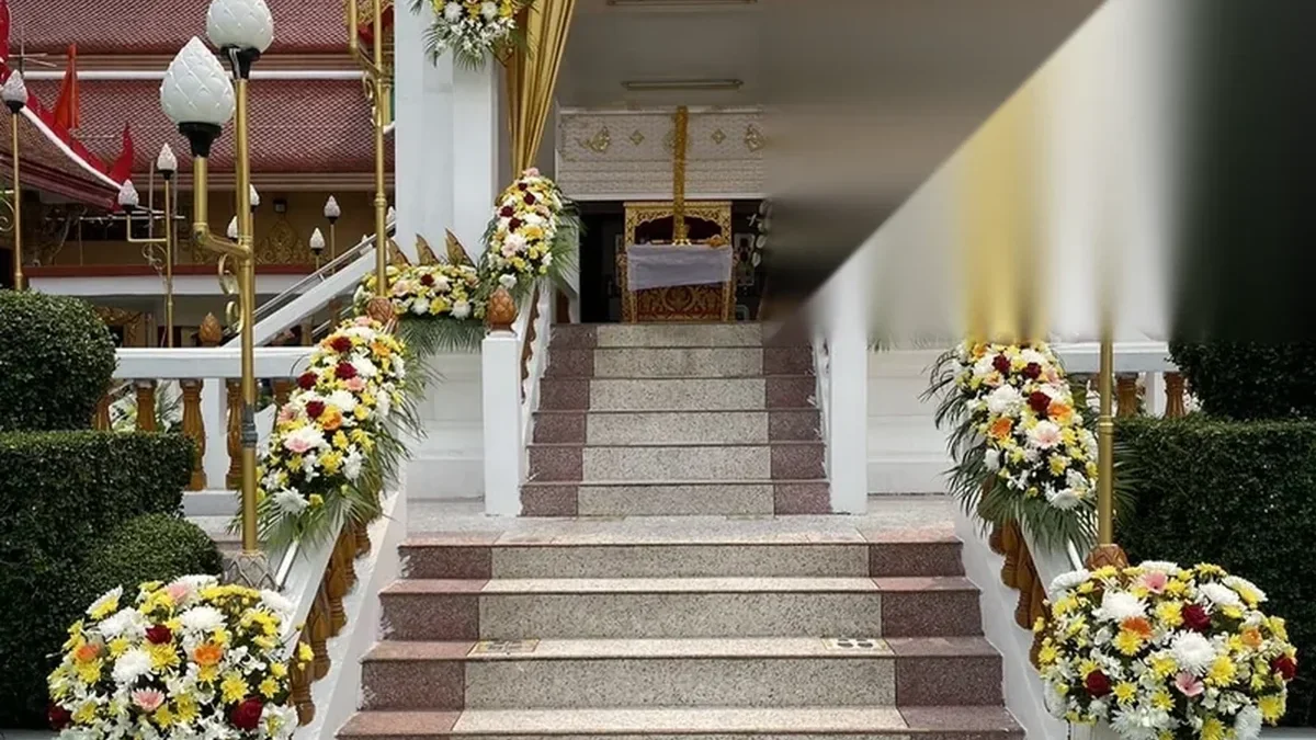 ทางขึ้นเมรุที่จัดดอกไม้โทนขาวไว้สองข้างสำหรับพิธีฌาปนกิจ